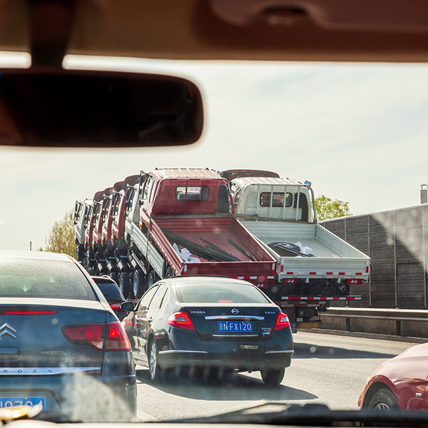 A truck carrying small trucks and vehicles on road