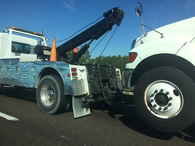 Tow truck wheel-lift connecting to a vehicle's front wheel in Greenville, SC