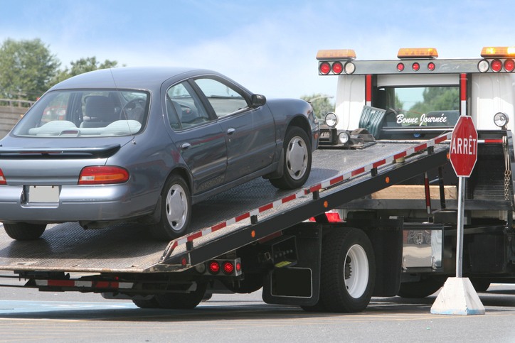 Car being loaded onto a tow truck ramp in Greenville, SC